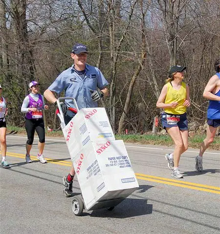 Delivery man pushing dolly in marathon