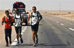Three men running across Sahara desert